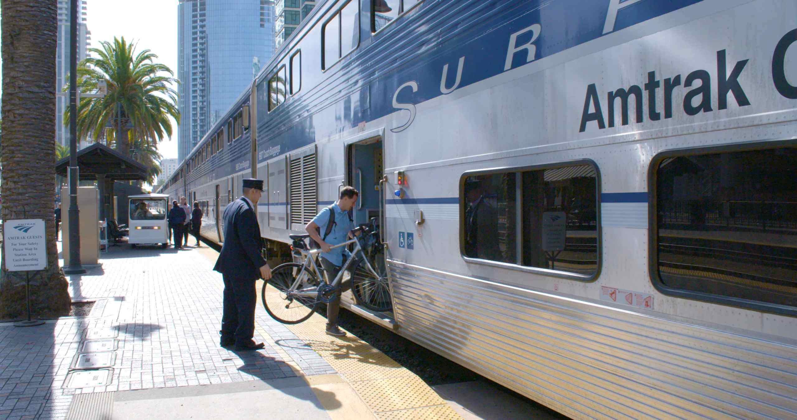Man bringing his bicycle onboard an Amtrak Pacific Surfliner train.