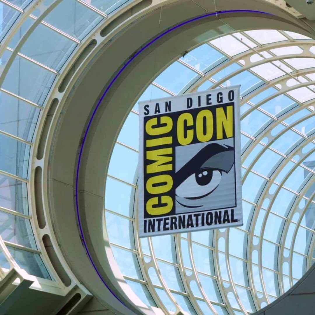 San Diego Comic-Con International banner hanging inside the glass-domed atrium of the San Diego Convention Center.