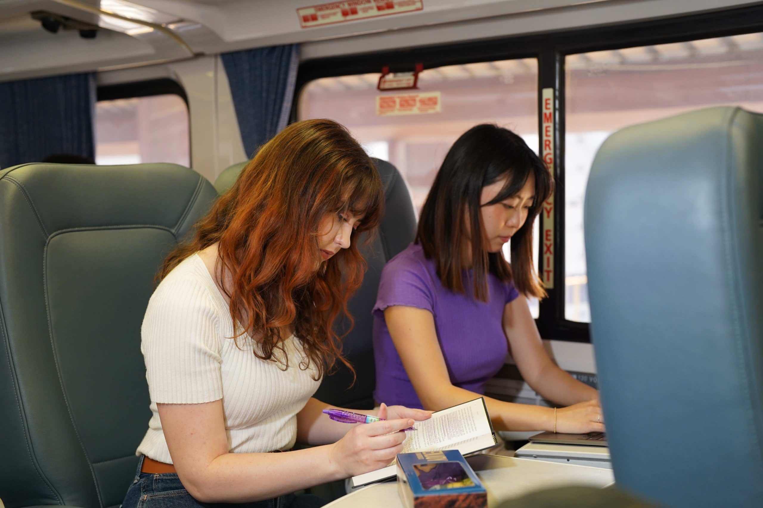 Passengers reading and working quietly on a train.