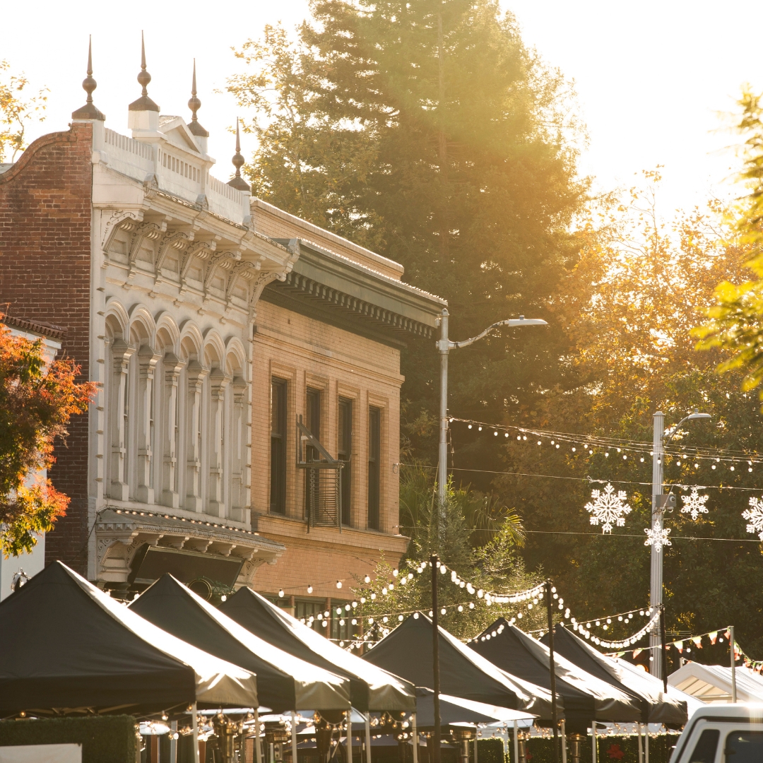 A street view of historic architecture and festival stalls in downtown San Luis Obispo.