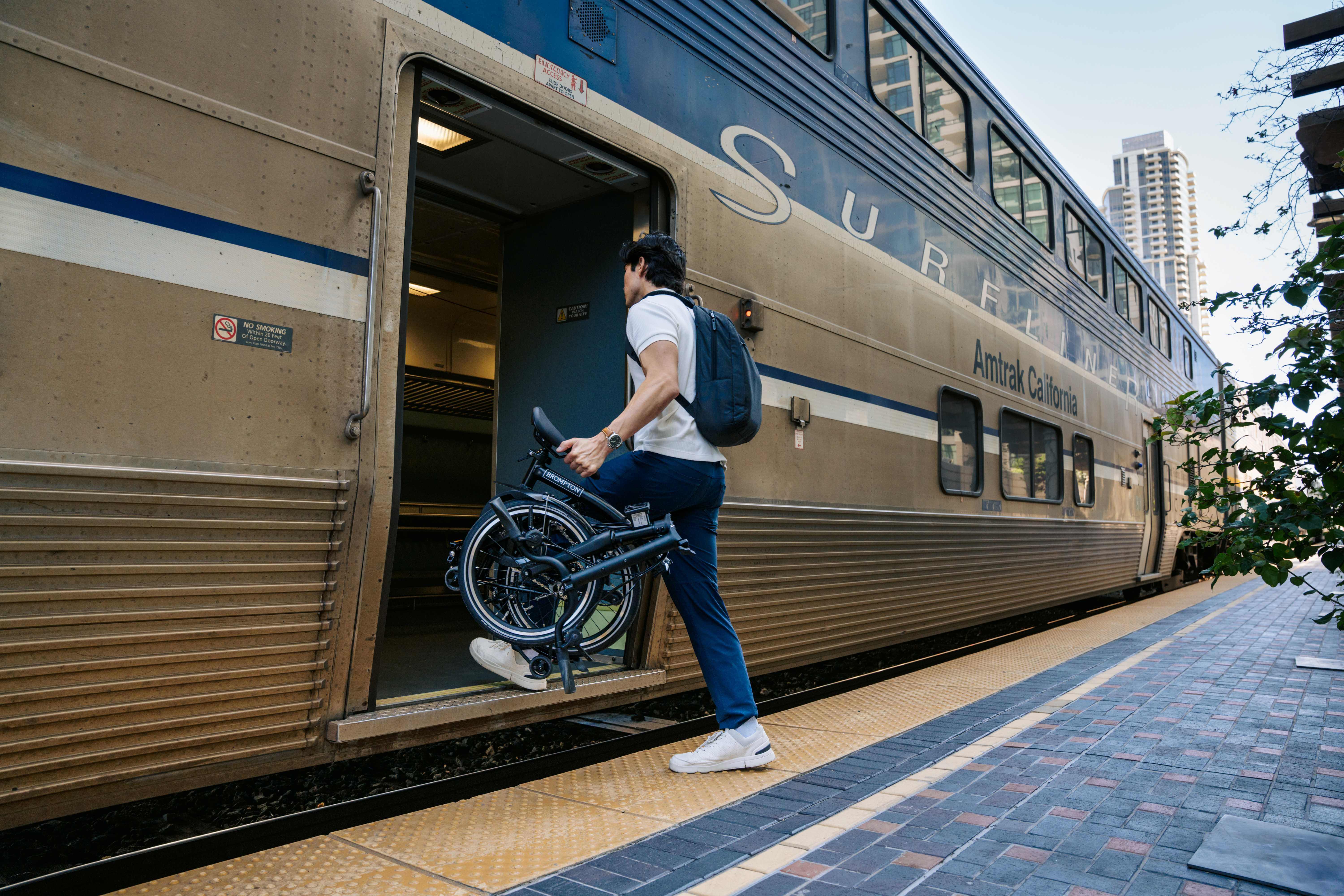 person with folding bike boarding pacific surfliner